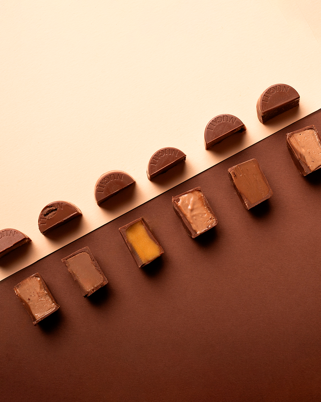 Bombons Nugali cuidadosamente produzidos com chocolate premium e recheios cremosos variados, oferecendo uma experiência sofisticada de sabor e textura.
