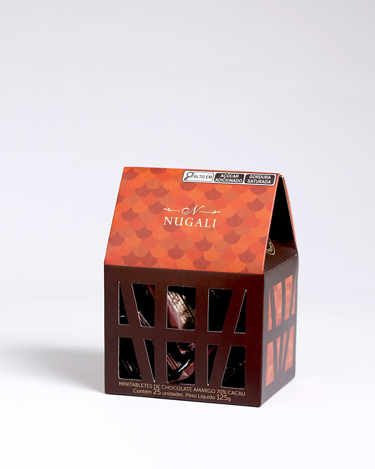 Caixinha Enxaimel com 25 mini tabletes de chocolate amargo embalados numa casa feita em papel que faz referência às peças de madeira da arquitetura enxaimel.
