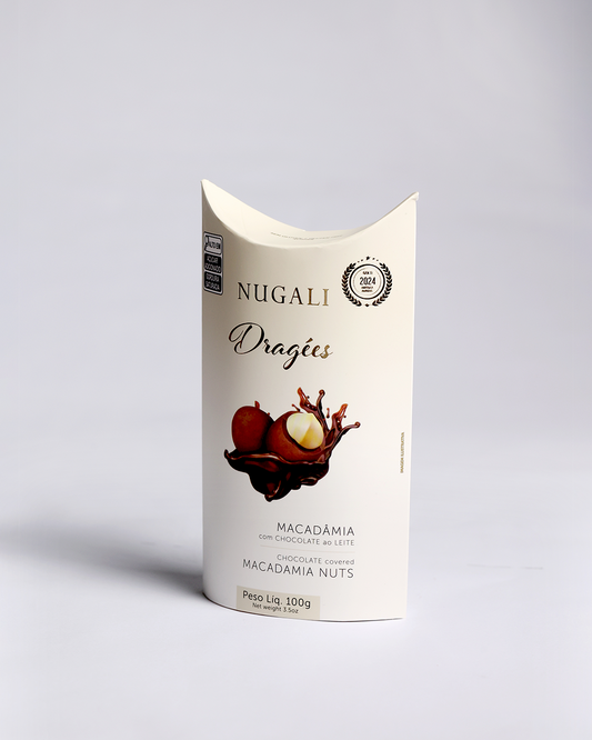 Dragée de macadâmias crocantes envolvidas em chocolate ao leite, destacando sua textura irresistível e brilho natural, símbolo de dragée saudável e gourmet”