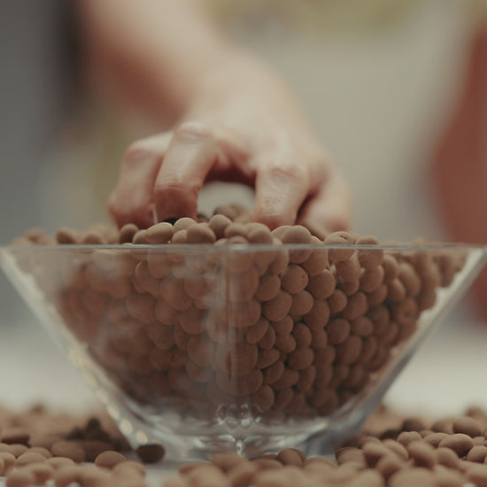 Dragée de nibs de cacau coberto com chocolate ao leite, premiado, feito com ingredientes selecionados de alta qualidade, ideal para quem aprecia chocolates gourmet.