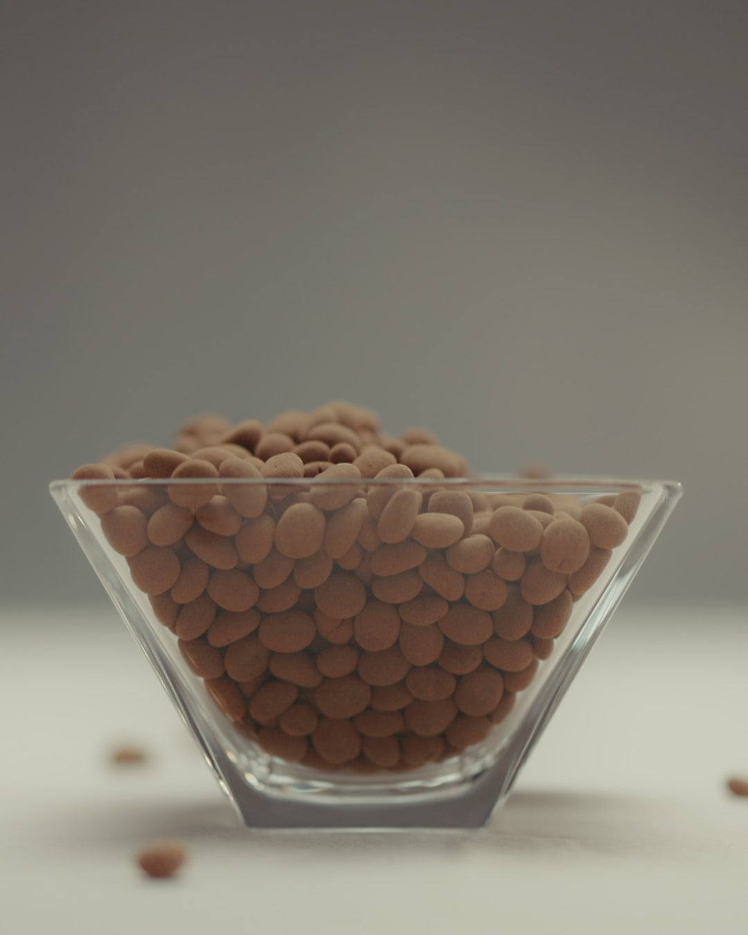 Dragée de nibs de cacau coberto com chocolate ao leite, premiado, feito com ingredientes selecionados de alta qualidade, ideal para quem aprecia chocolates gourmet.